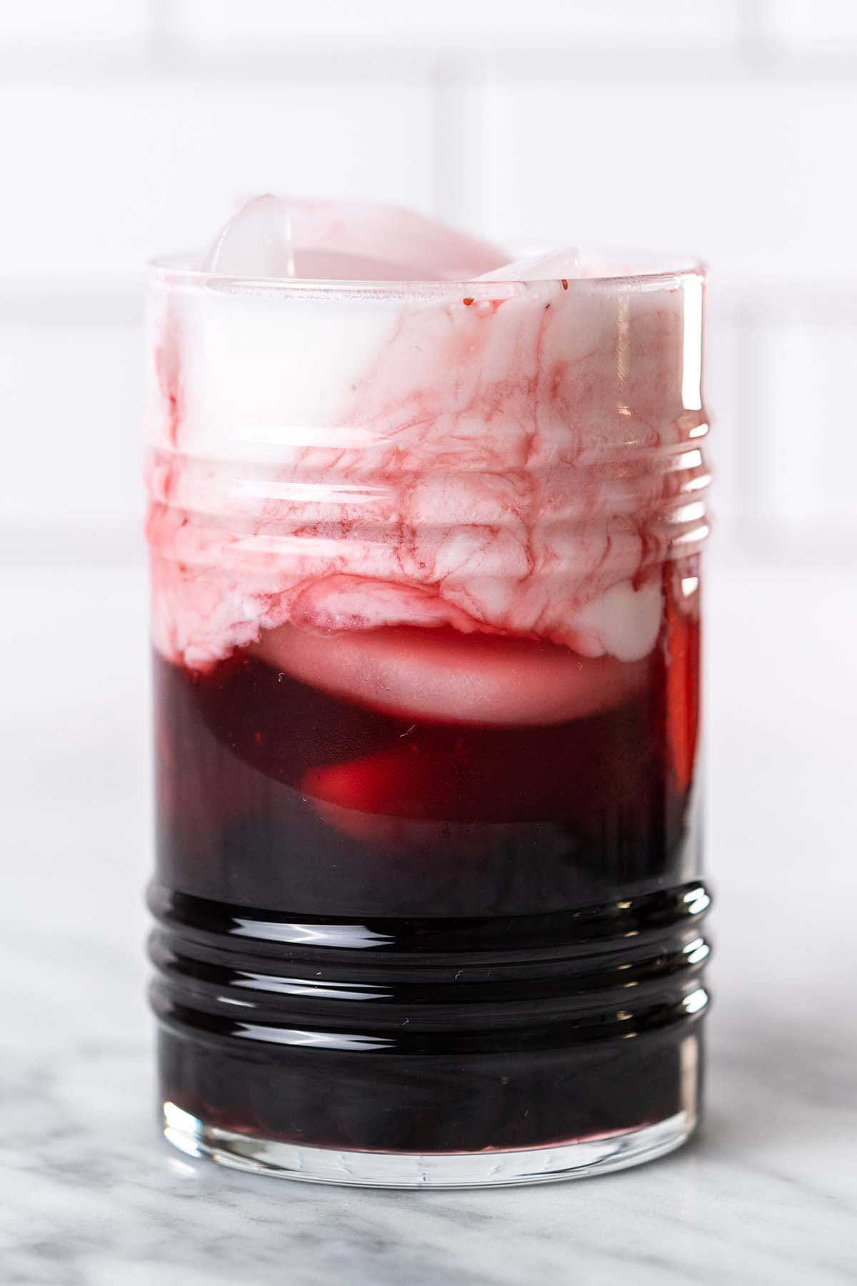 coconut milk swirling in strawberry drink with boba