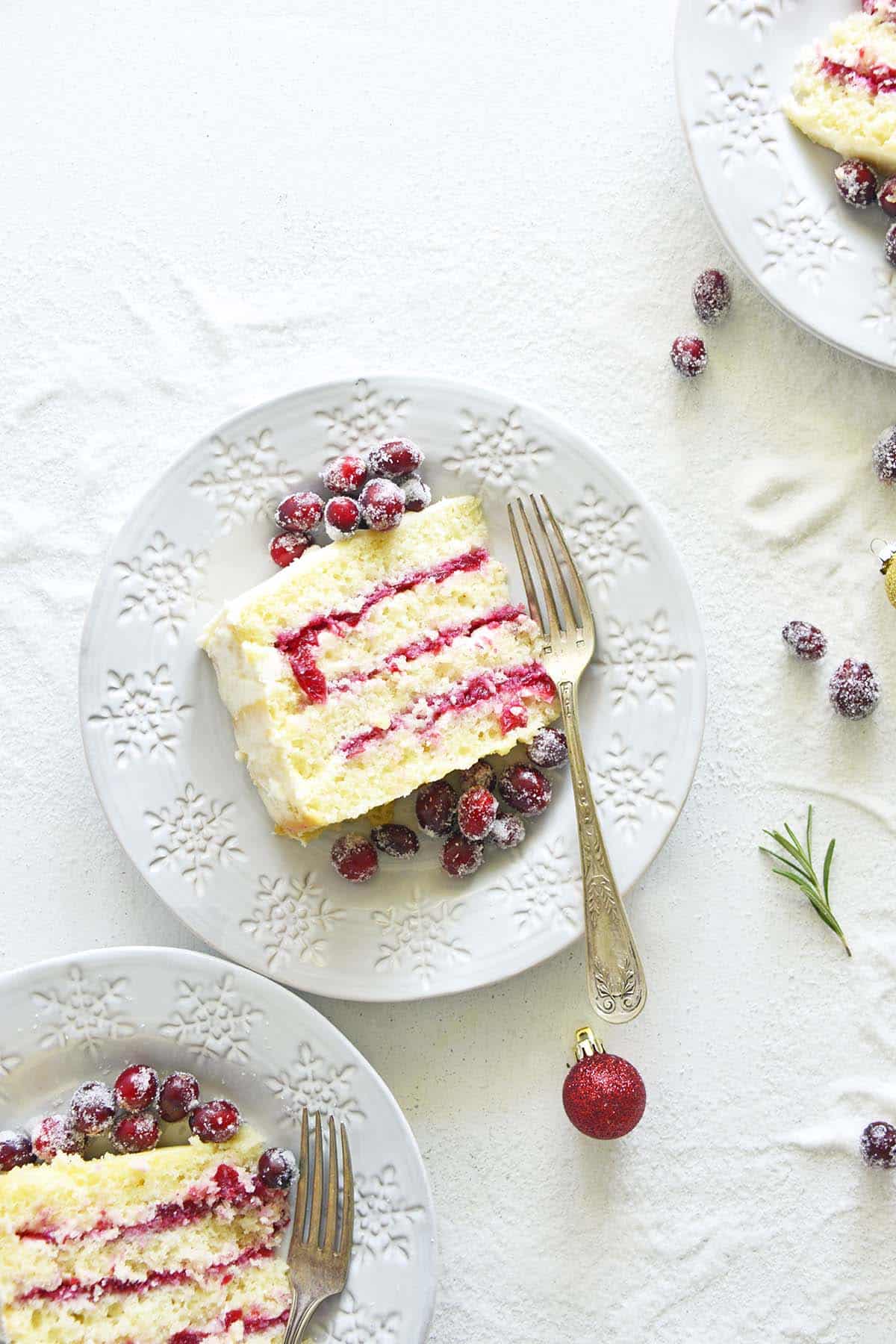 slices of festive cranberry dessert cake on white snowflake plates