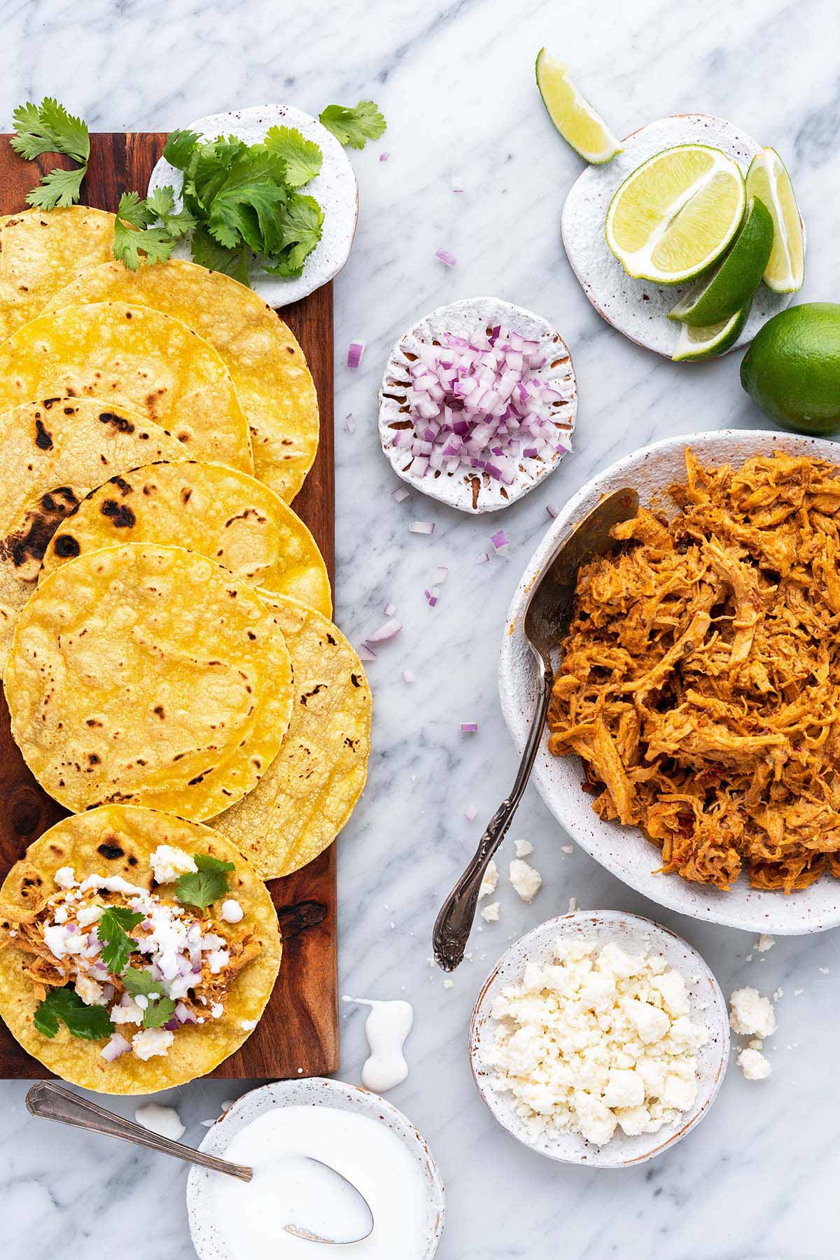 overhead view of spread for making pulled chicken tacos with queso fresco