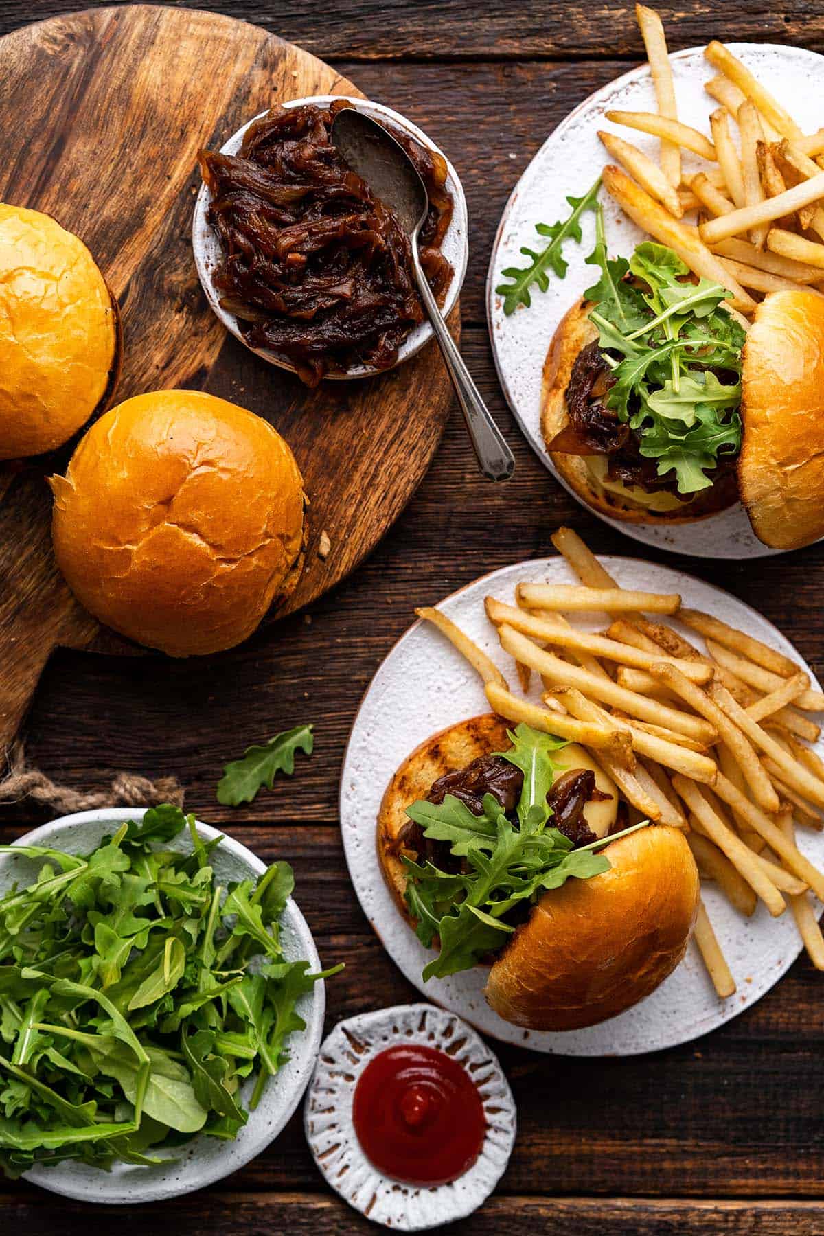 overhead view of spread of gourmet burgers with caramelized onion swiss cheese and arugula