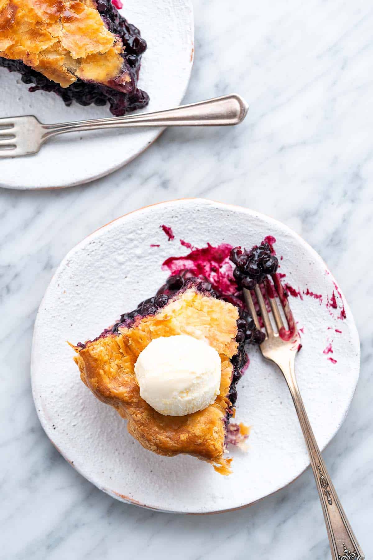 overhead view of 2 slices of easy blueberry pie with vanilla ice cream