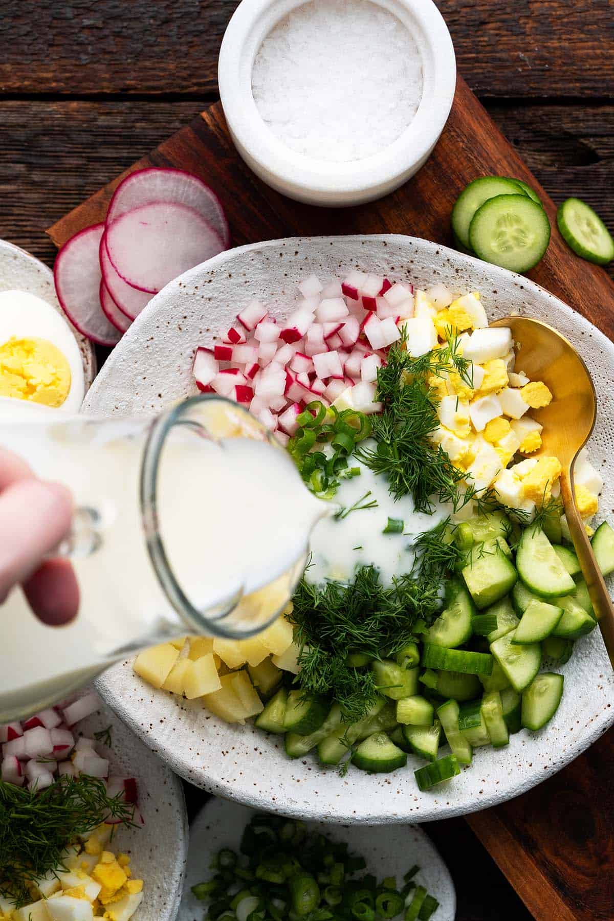 pouring kefir and mineral water mixture into okroshka