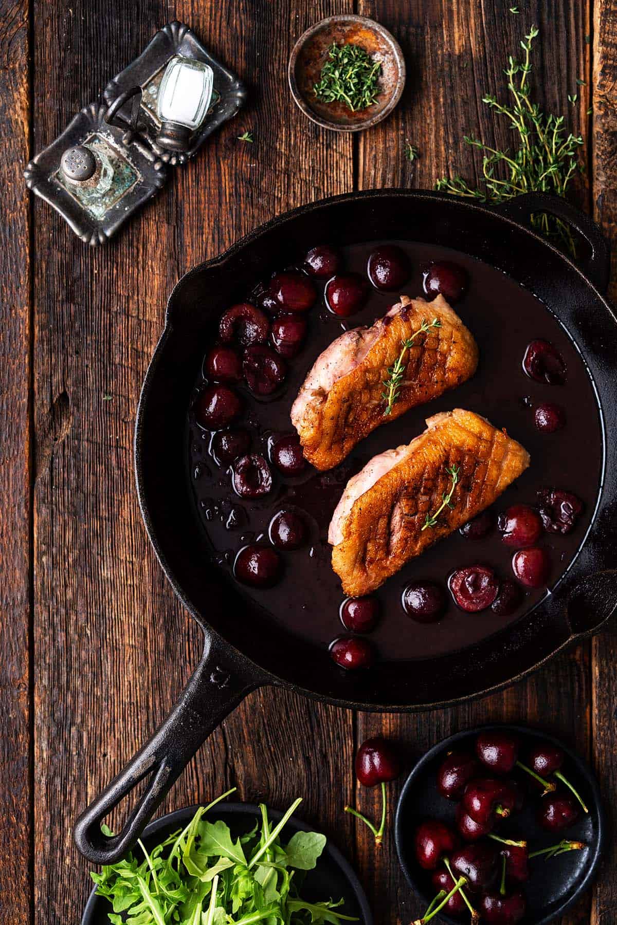 crispy pan seared duck breast recipe with cherry sauce in cast iron skillet