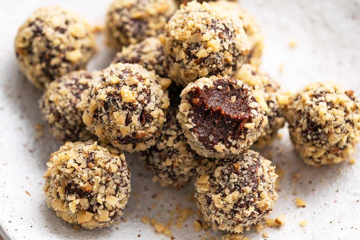 date cocoa balls on white plate with bite taken out of one