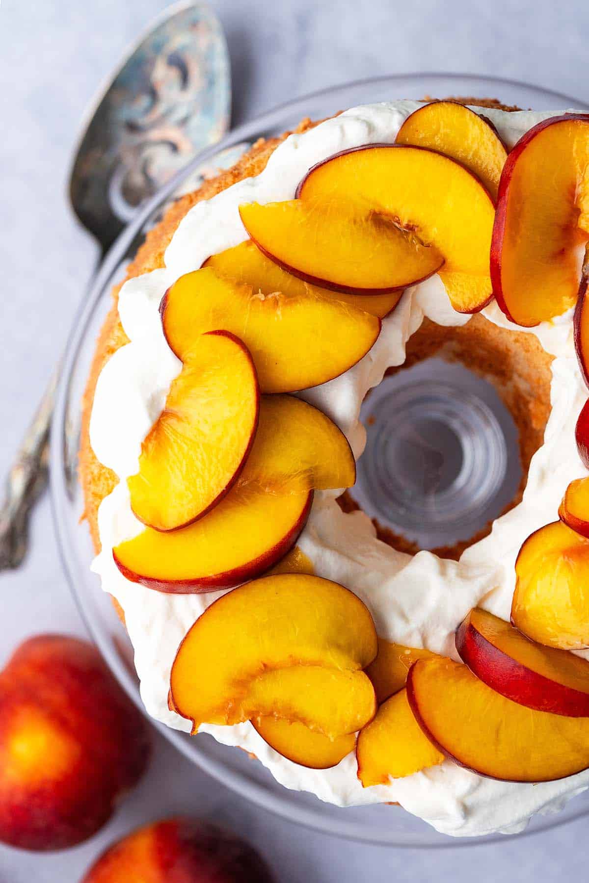 overhead view of homemade angel food cake topped with fresh peaches