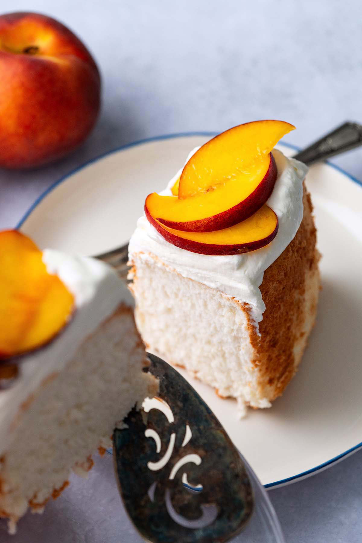 slice of light and fluffy angel food cake topped with whipped cream and fresh fruit