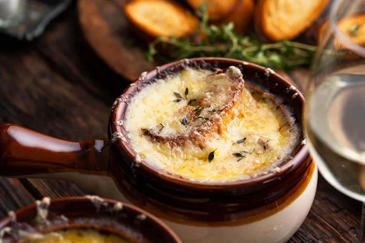 bowl of french onion soup topped with toasted baguette and cheese