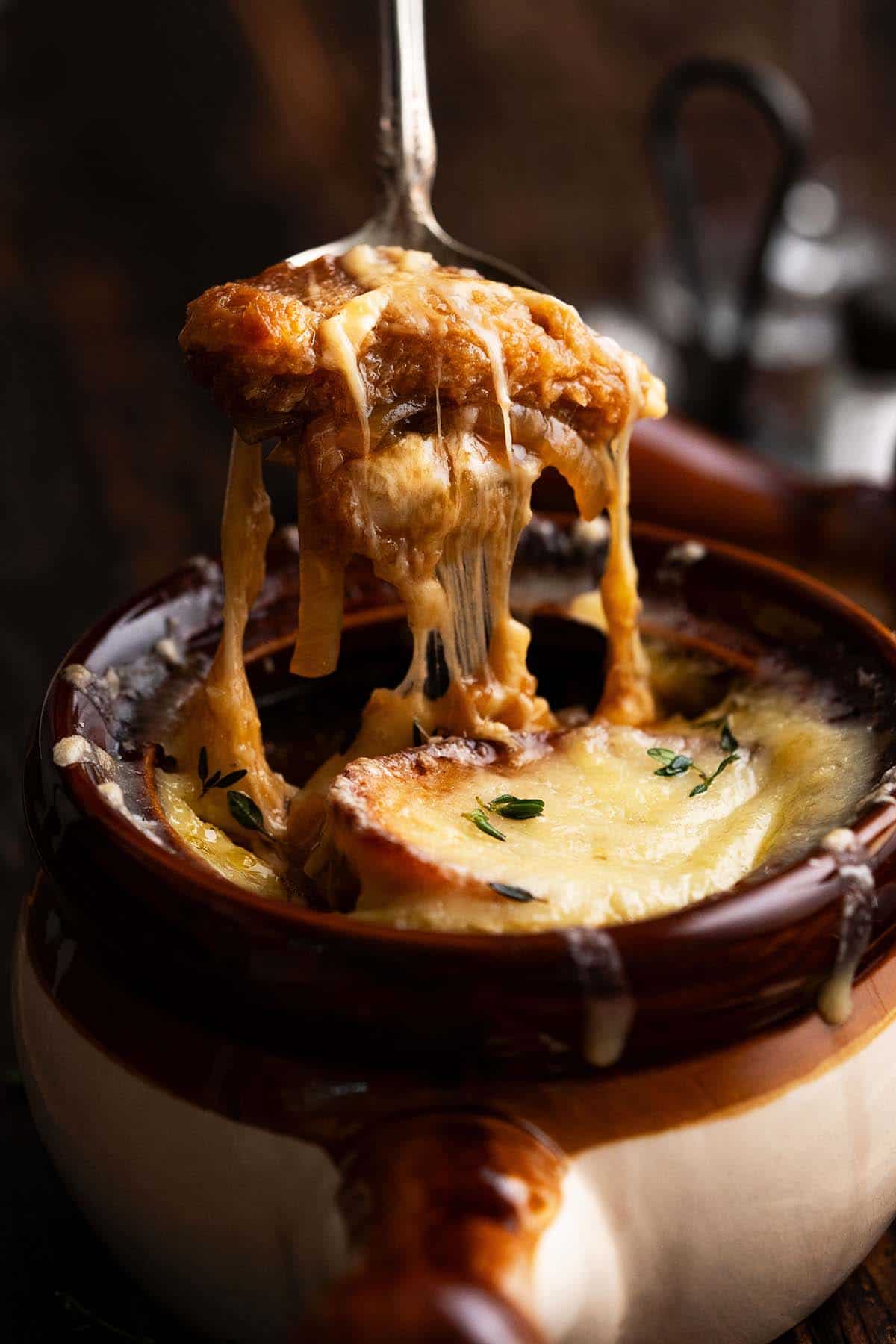 spoonful of french onion soup with crouton and cheese