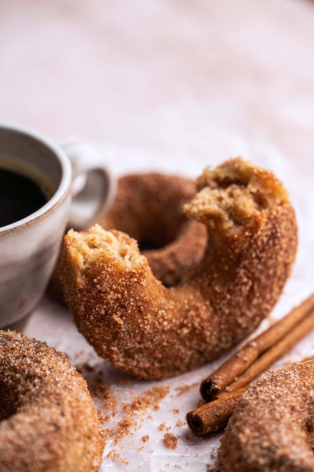 homemade baked apple cider cinnamon doughnuts with cup of coffee