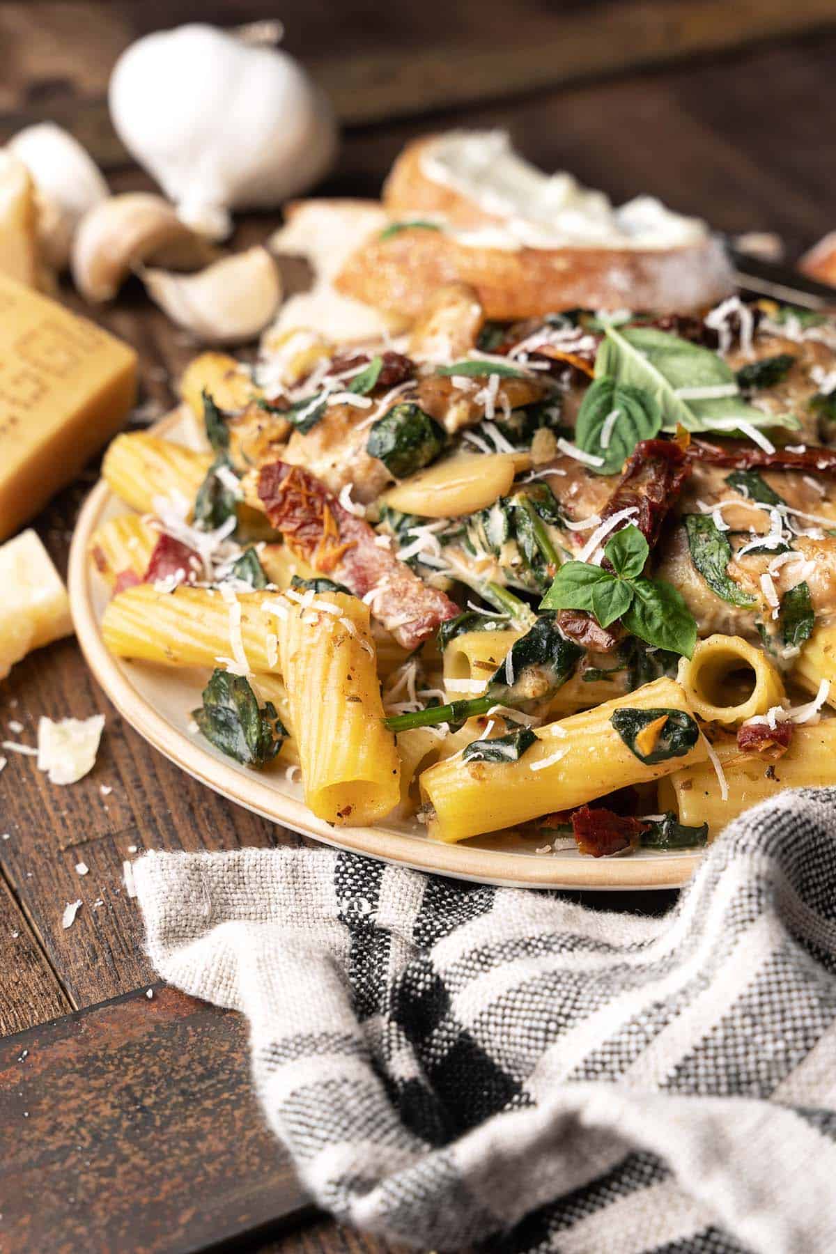 front view of plate of slow cooker tuscan chicken on bed of rigatoni with parmesan