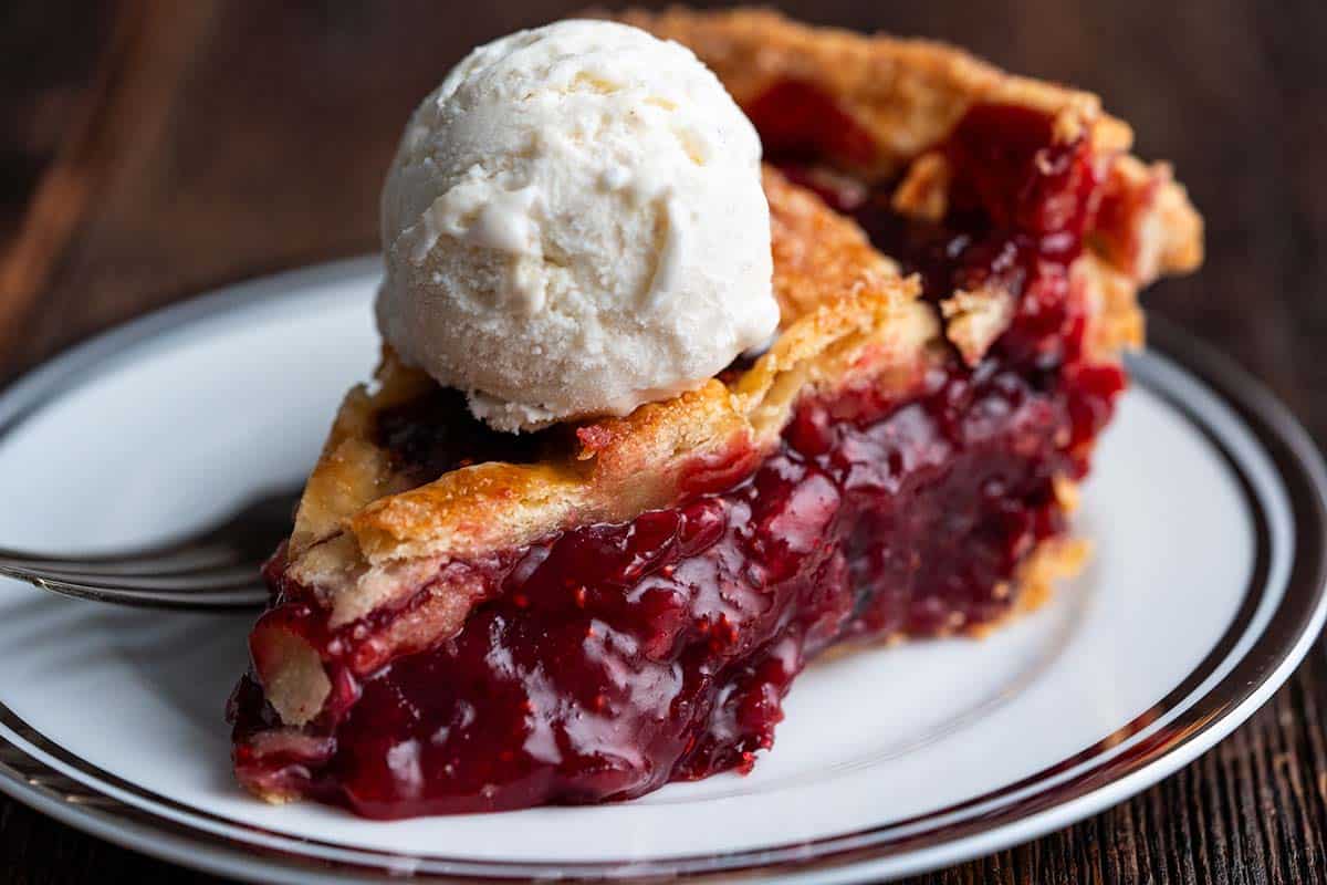 slice of thanksgiving cranberry pie on plate topped with vanilla ice cream