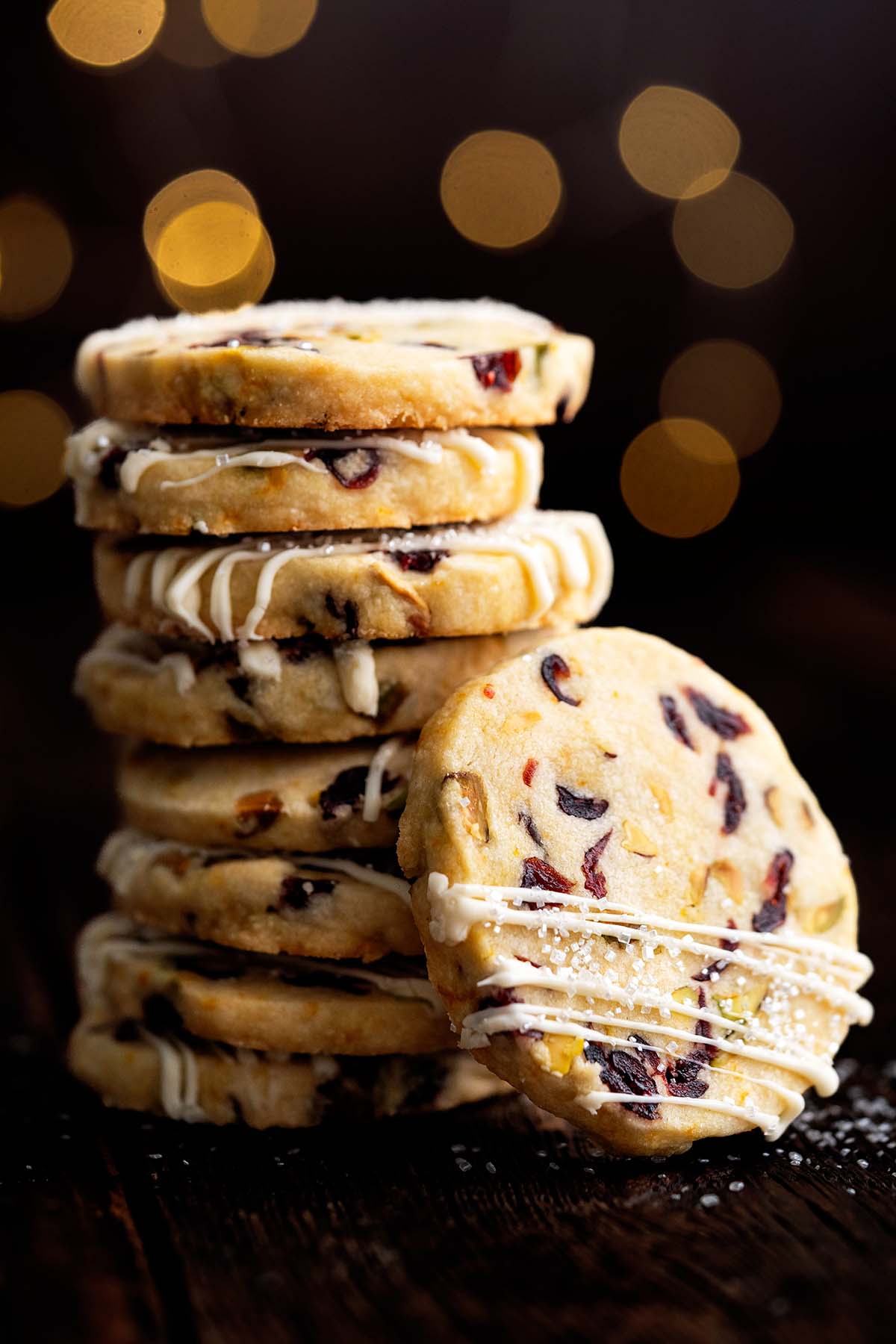 stack of shortbread christmas cookies on wooden table with bokeh