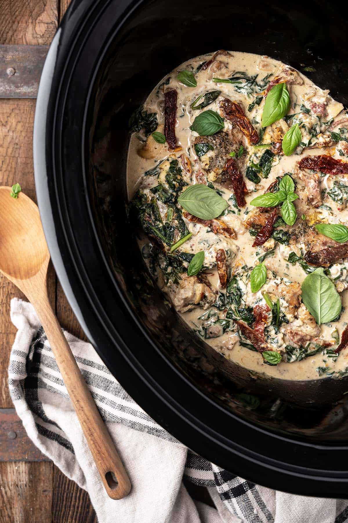 top view of creamy tuscan chicken with sun-dried tomatoes in slow cooker