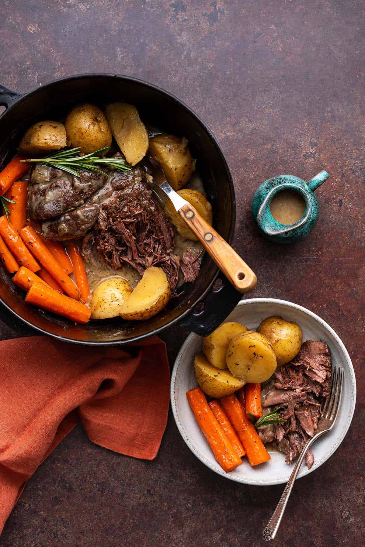 overhead view of pot roast meal in dutch oven with serving on the side