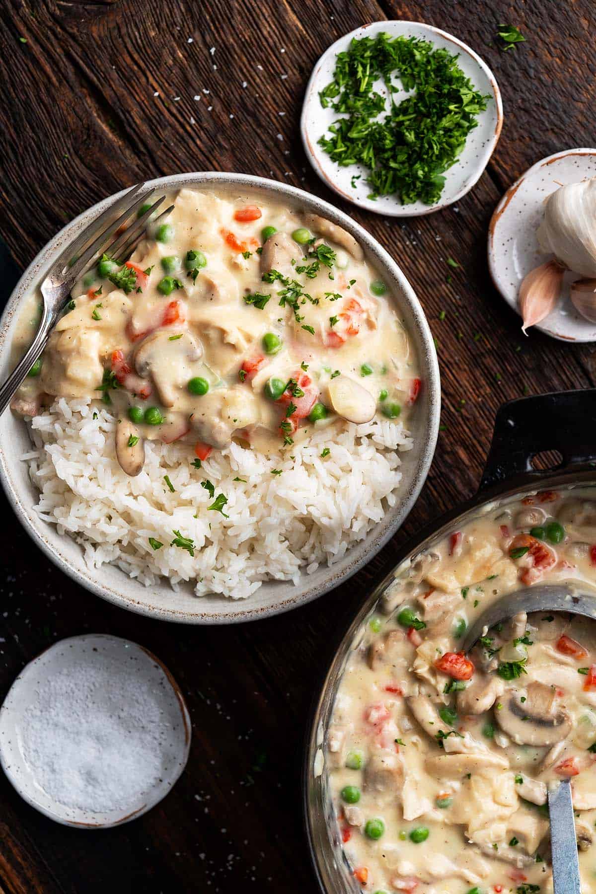 chicken a la king sauce in dutch oven with plated meal on steamed rice