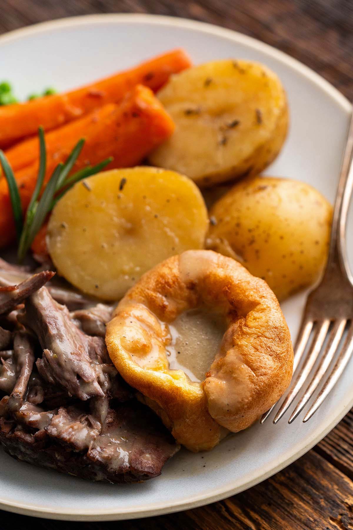 close up front view of Yorkshire pudding with gravy and roast beef