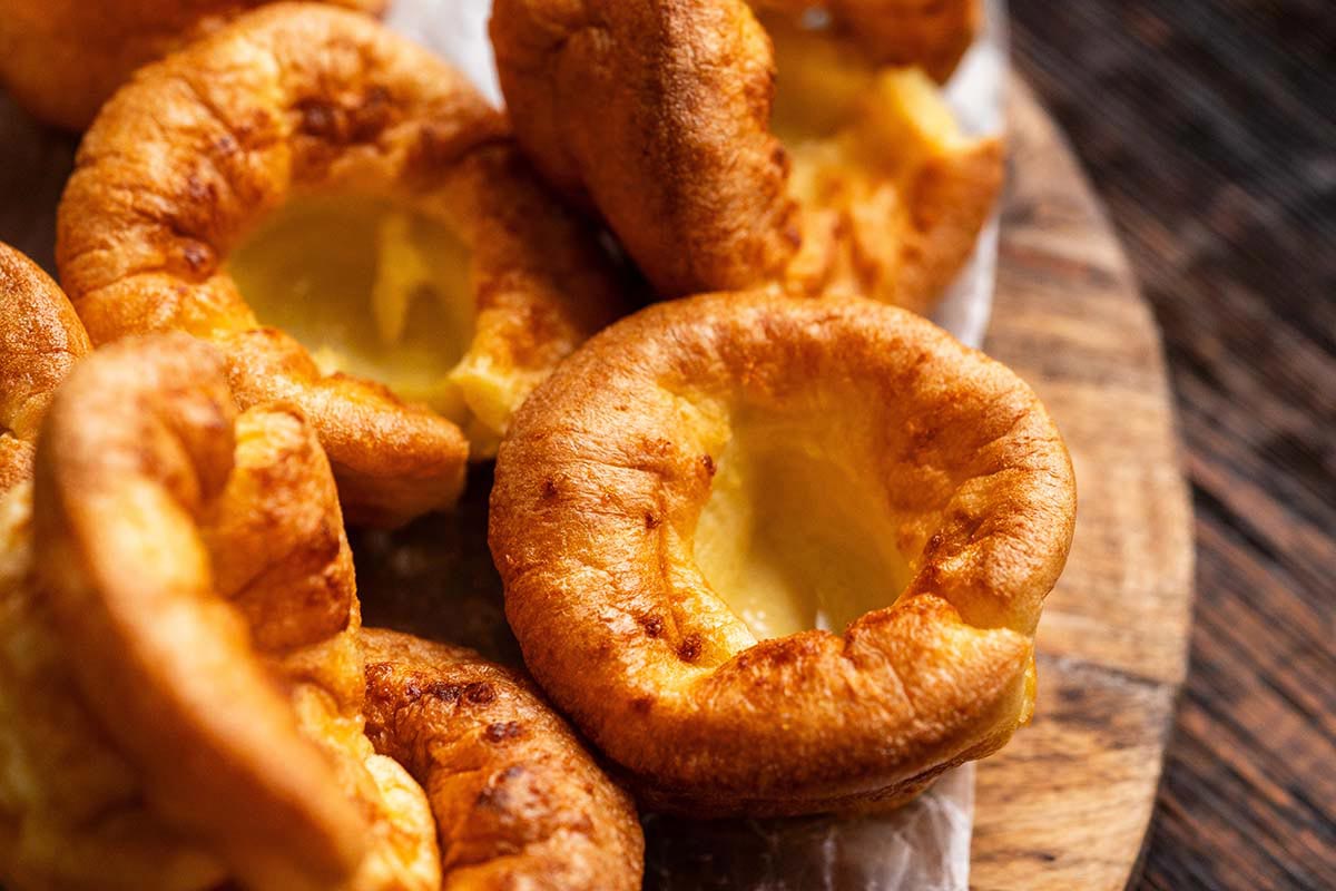 crispy golden Yorkshire puddings on wooden bread board