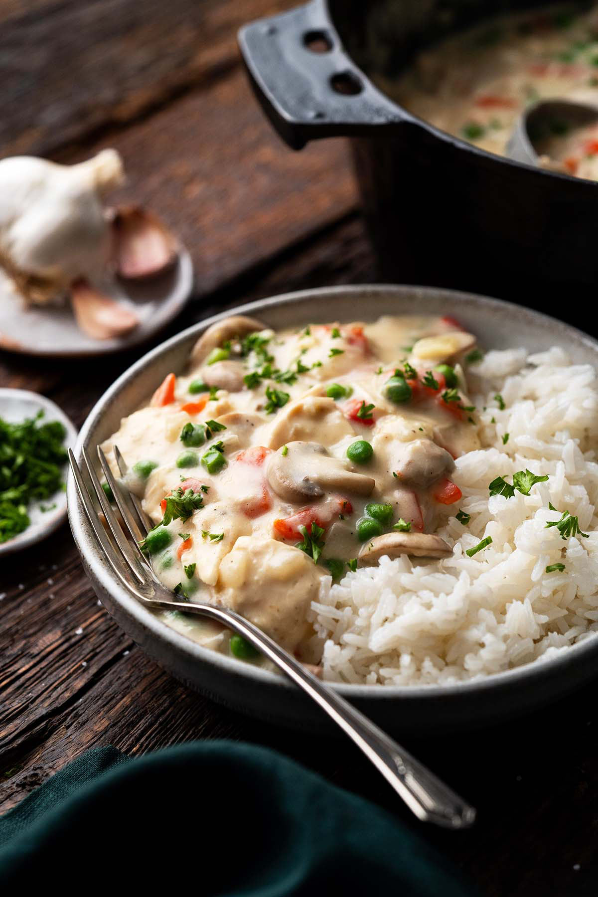 old fashioned chicken a la king on a bed of rice next to dutch oven pot