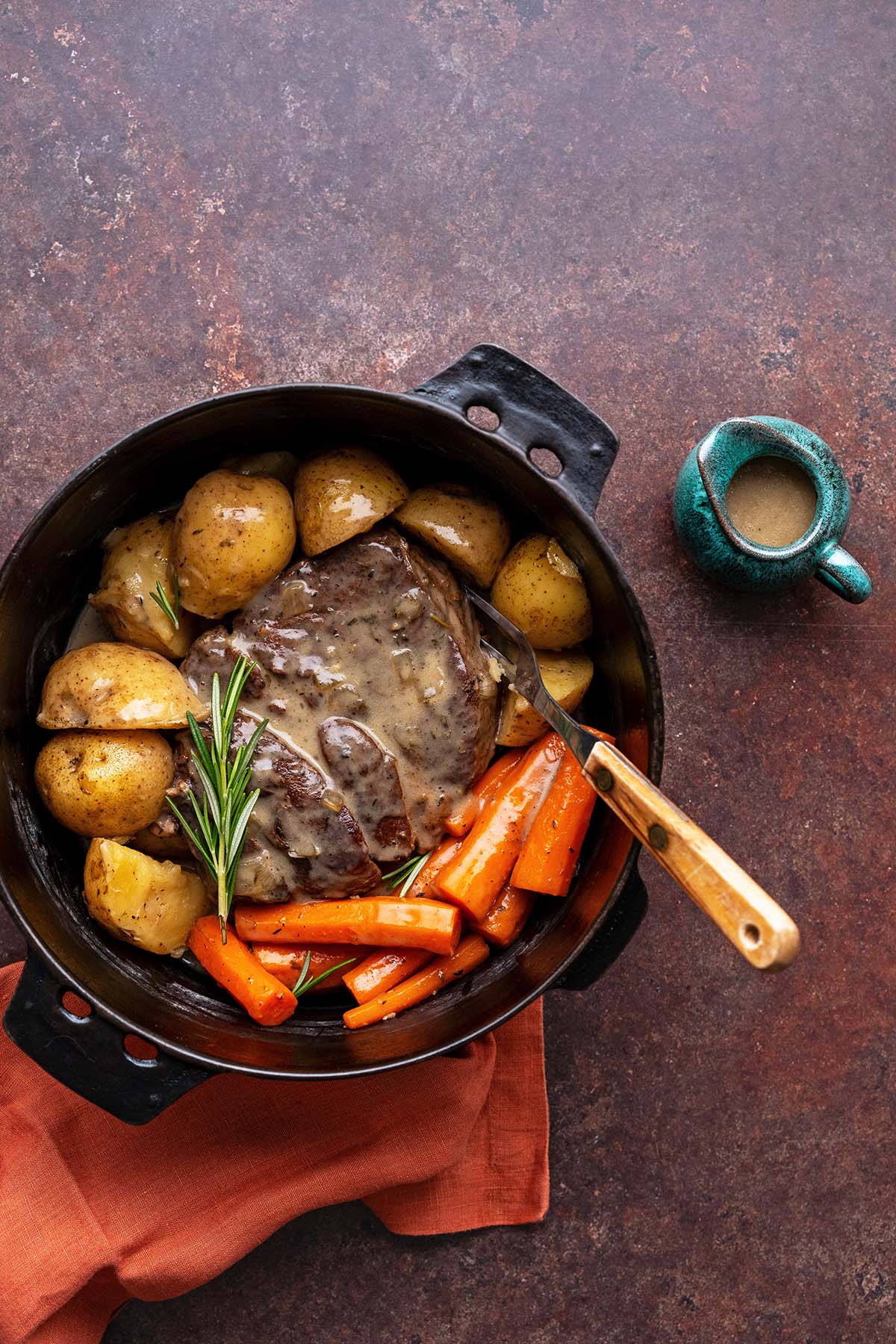 pot roast meal with vegetables and gravy cooked in dutch oven