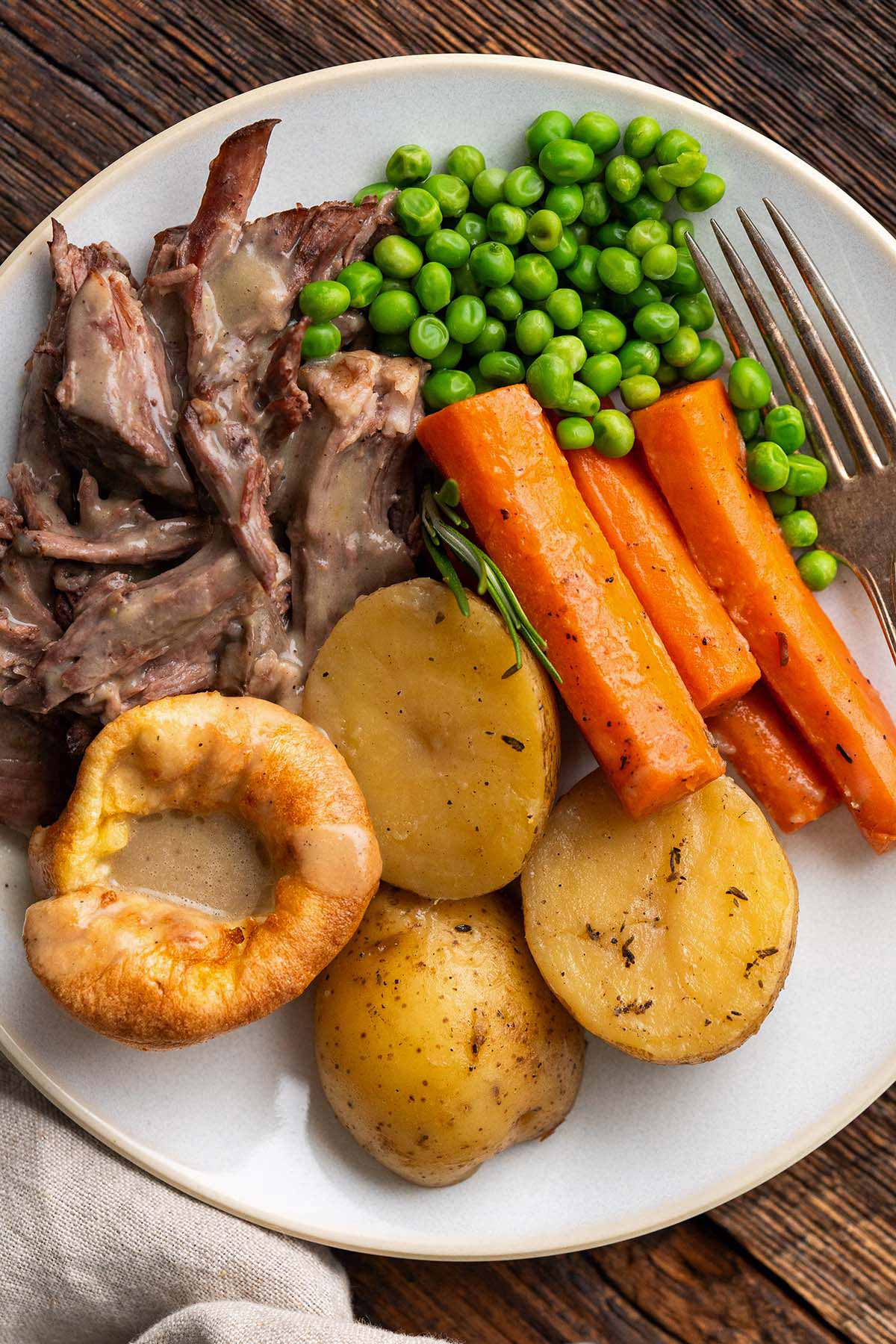 Sunday roast dinner with Yorkies, peas, and carrots
