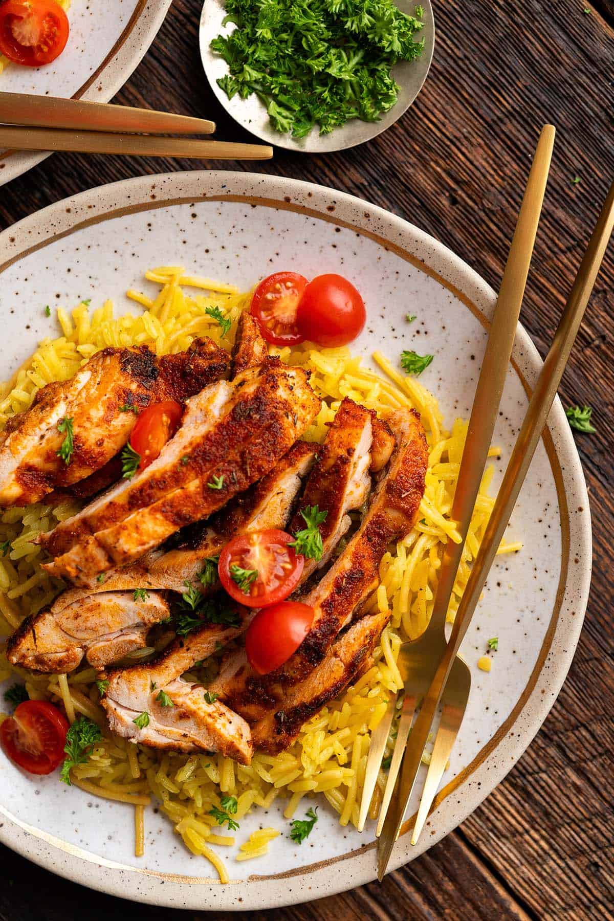 close up overhead view of blackened chicken thighs with yellow rice