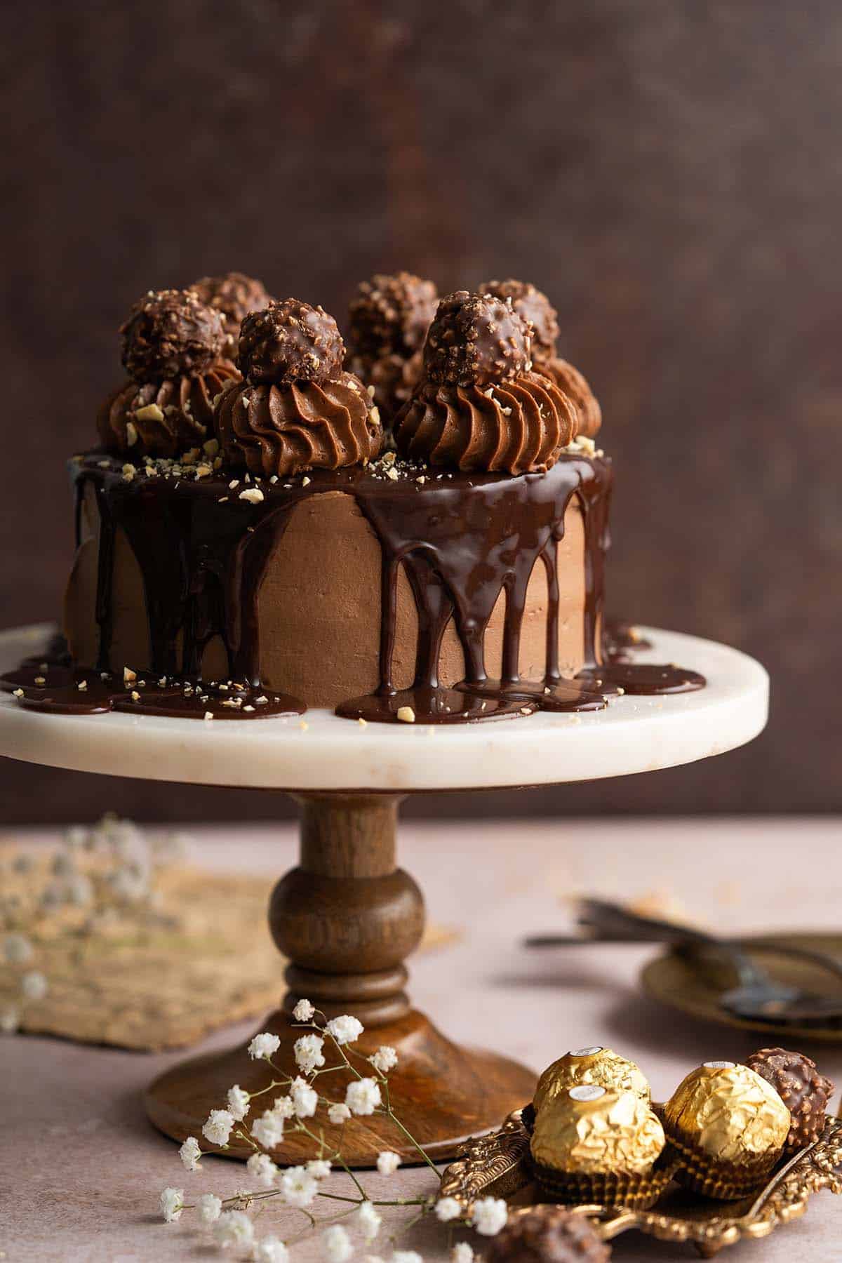 nutella cake recipe with nutella frosting on marble and wood cake stand