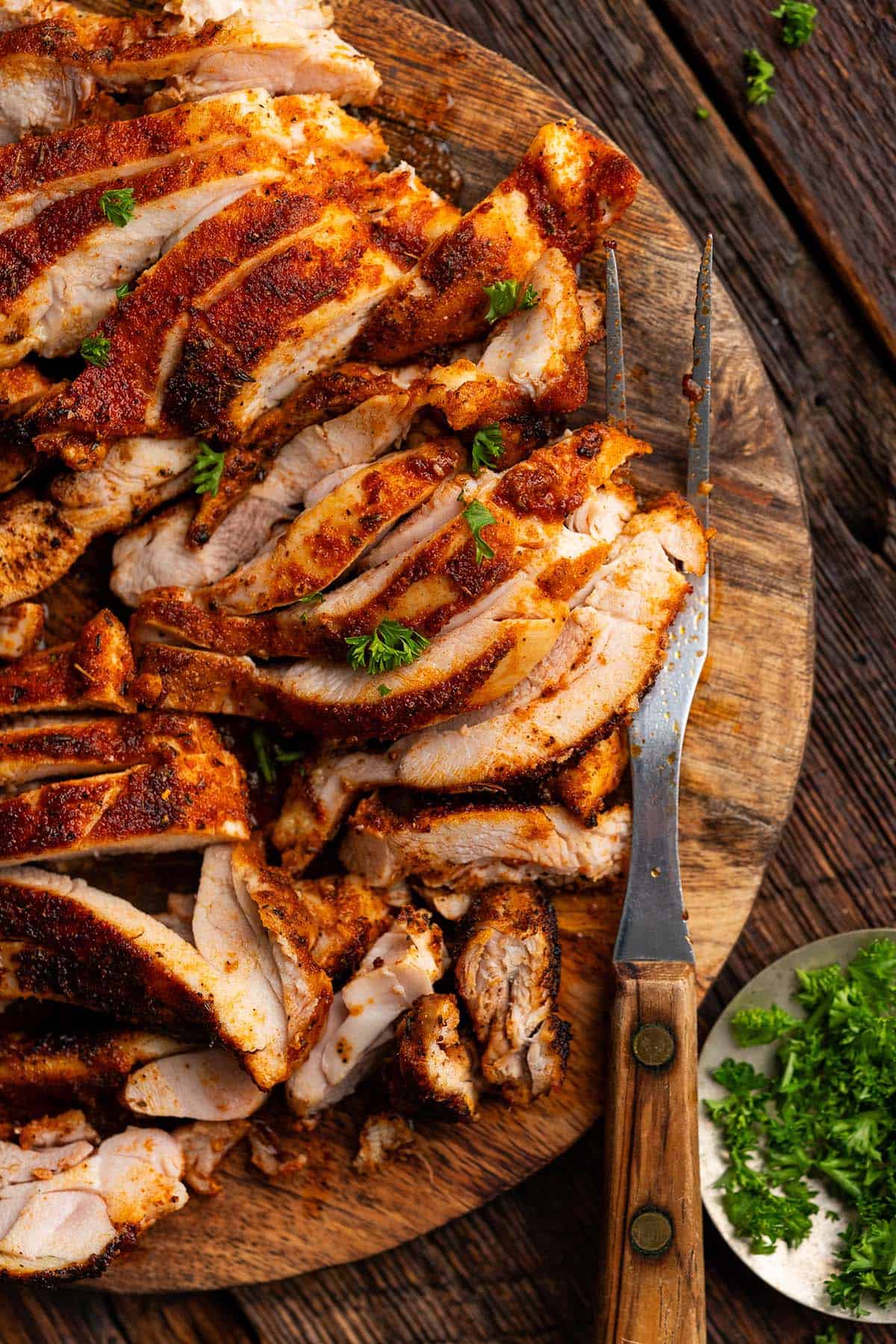 tender juicy sliced blackened chicken on wooden cutting board