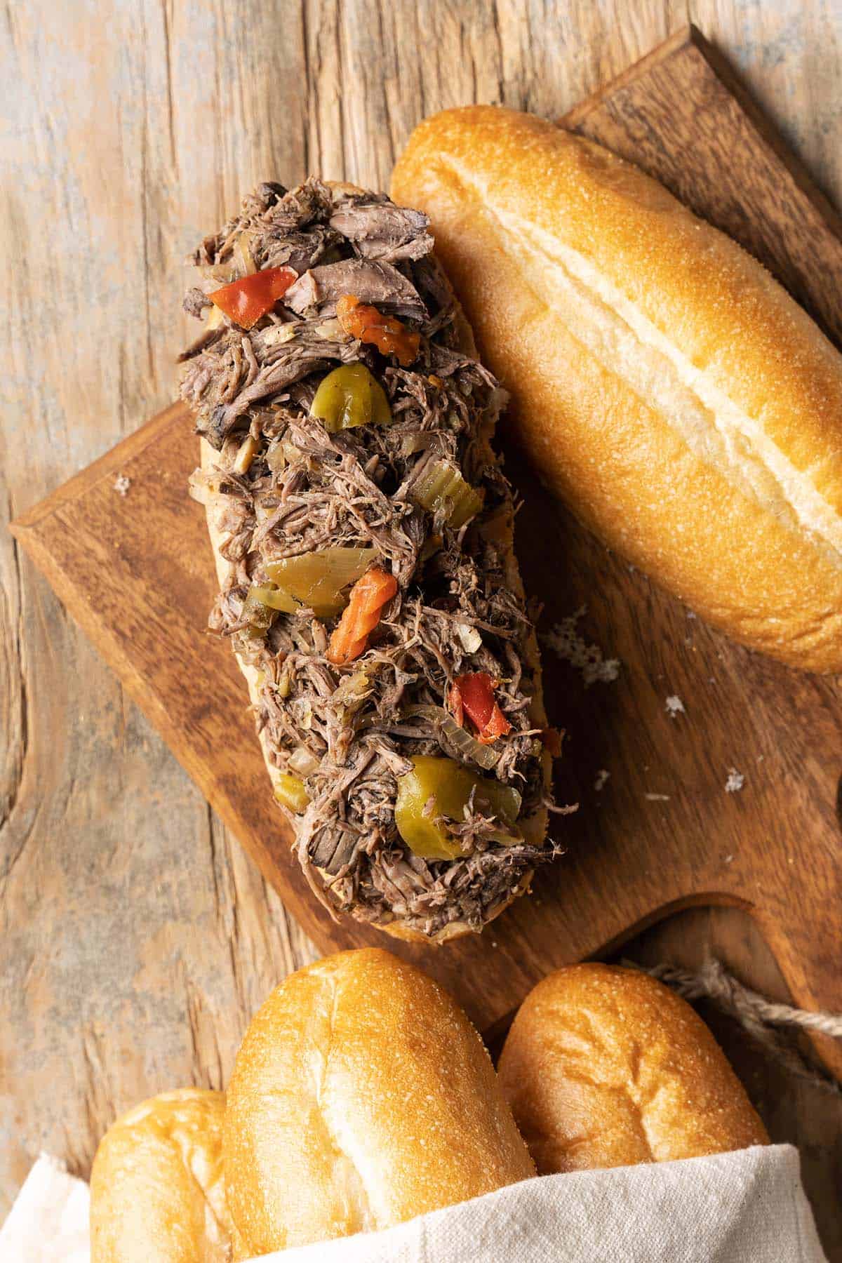 top view of crockpot shredded italian beef and peppers on fresh roll