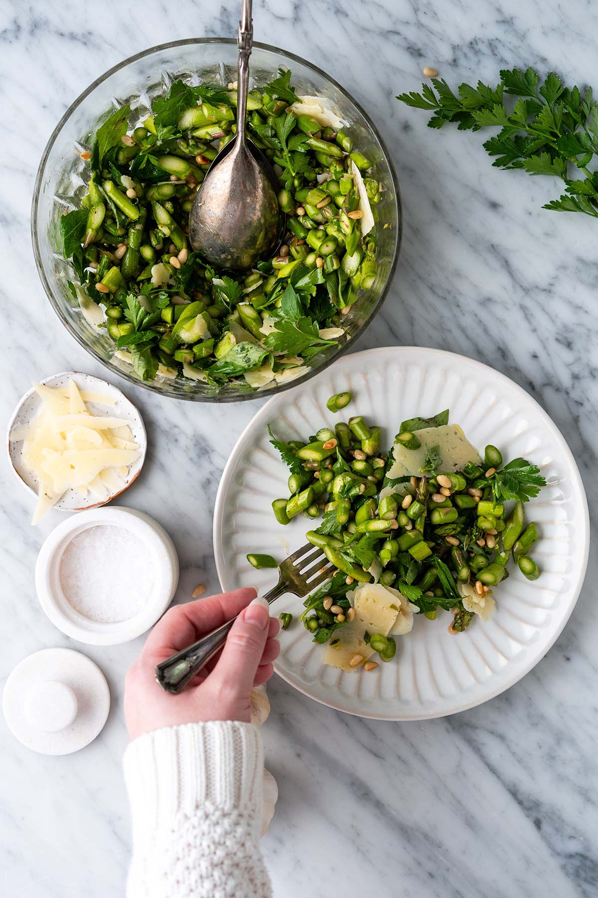 hand holding fork in asparagus salad