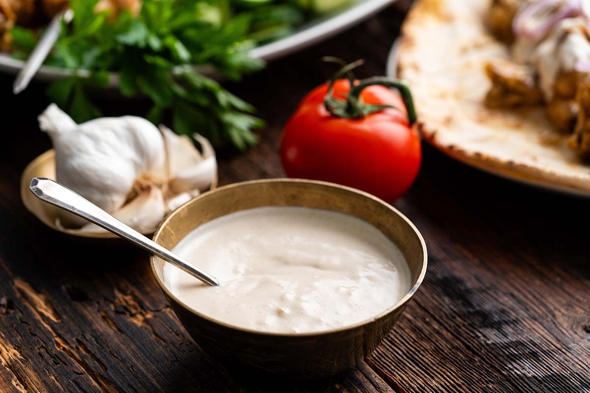 bowl of whtite sauce for shawarma on wooden table