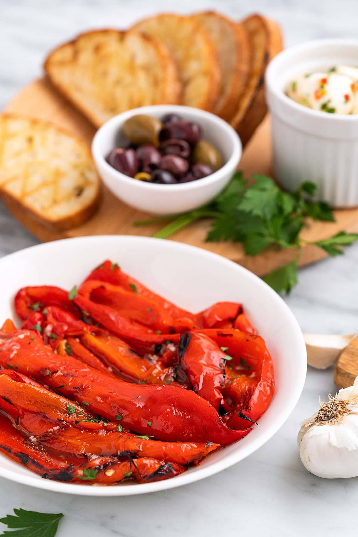front view of grilled red peppers in white bowl