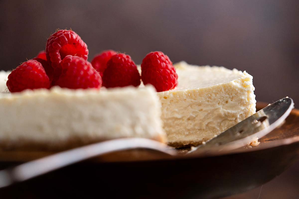 front view of healthy cottage cheese cheesecake topped with raspberries
