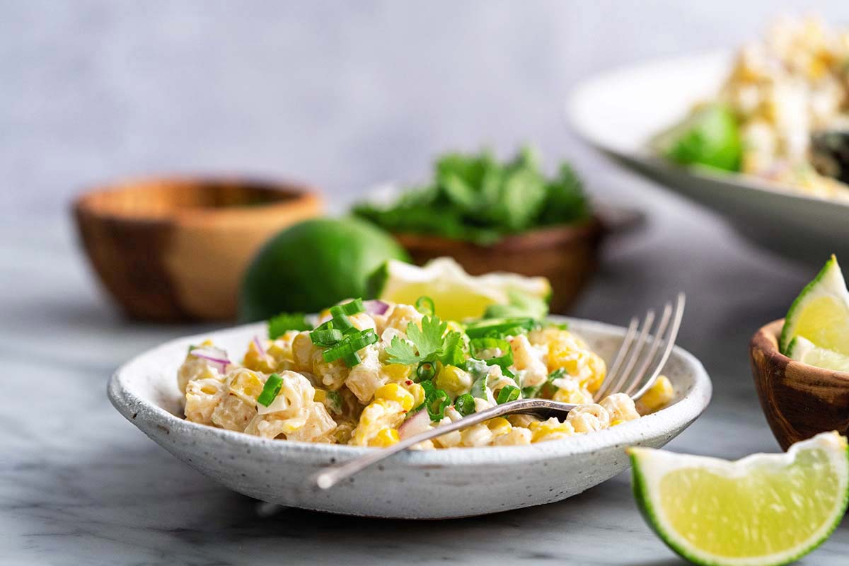 mexican elote pasta salad in white stoneware bowl