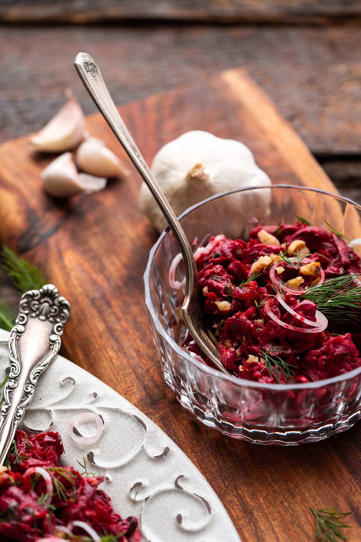fancy glass serving bowl with beet salad with mayonnaise walnuts and fresh herbs