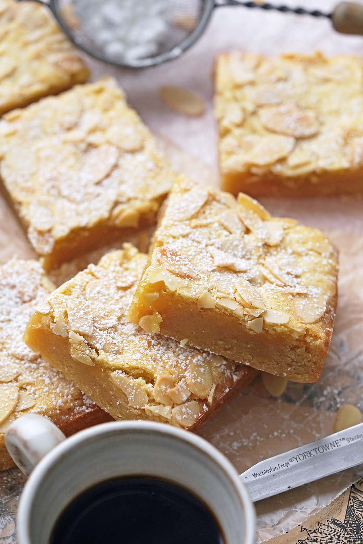 front view of almond frangipane bar cookies with coffee cup in front