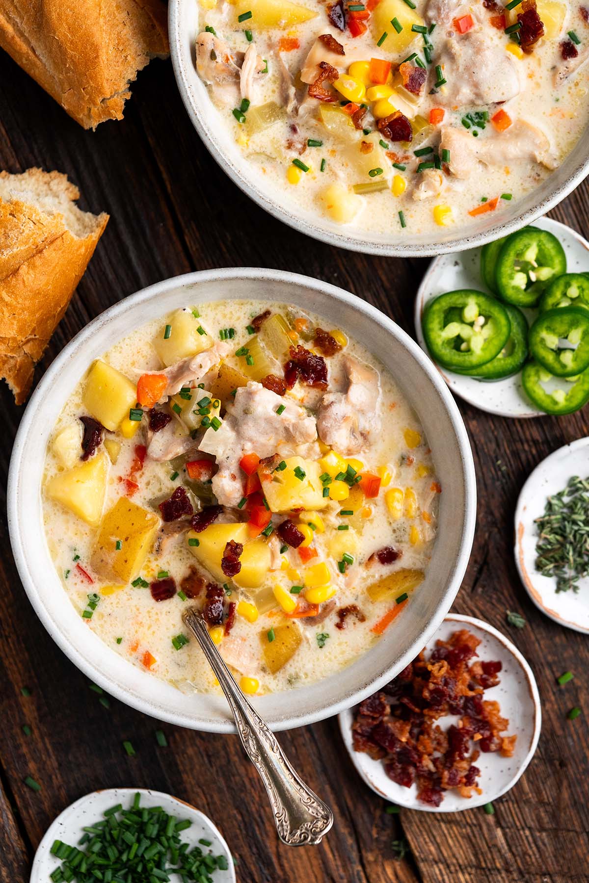 top view of bowls of chicken corn chowder with bacon and potatoes on rustic wooden table