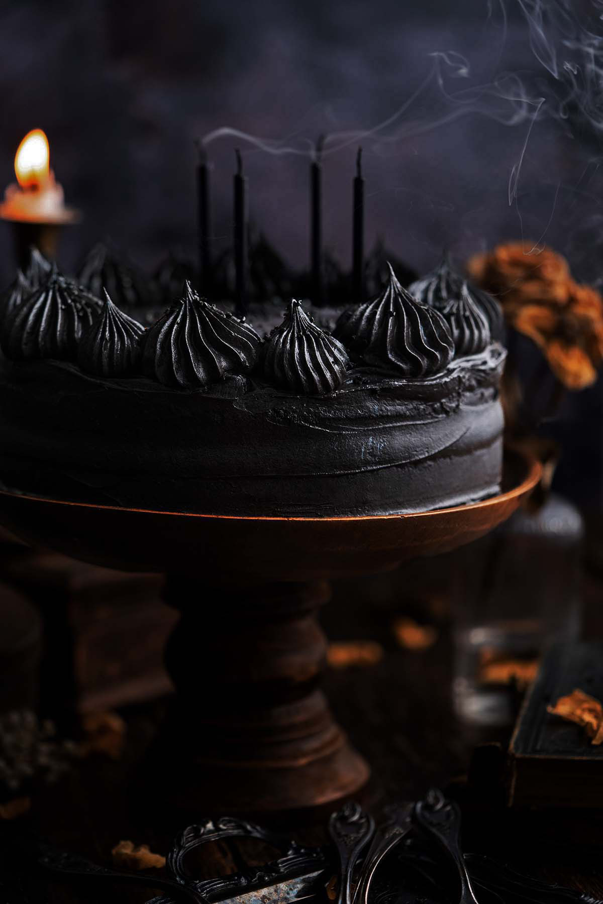 black velvet layer cake with candles and smoke