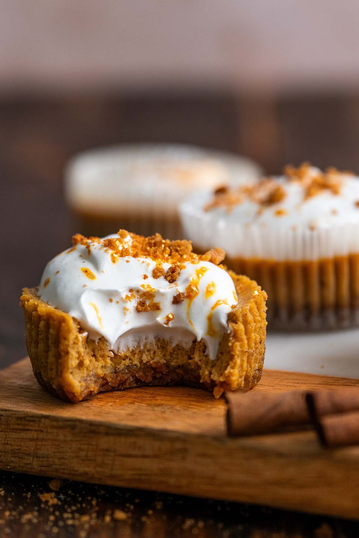 pumpkin cheesecake cupcake with bite to show creamy texture