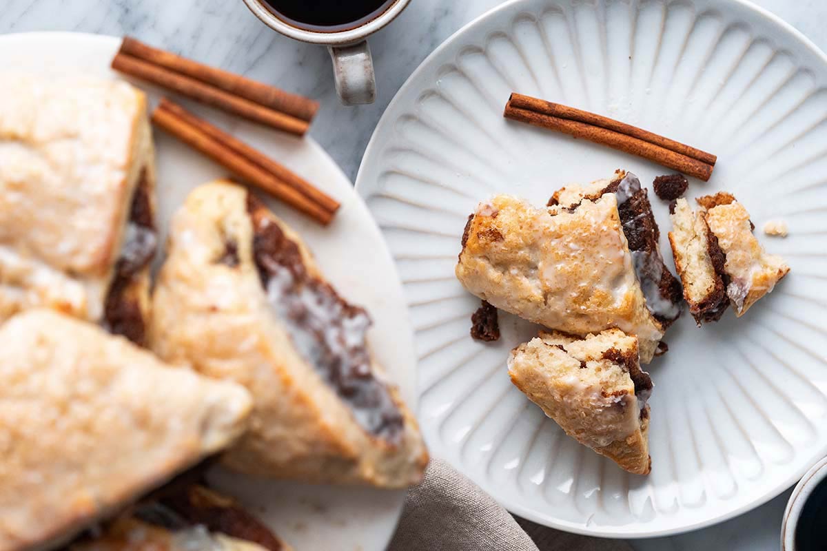 flaky buttery sourdough scones with cinnamon filling next to cup of coffee