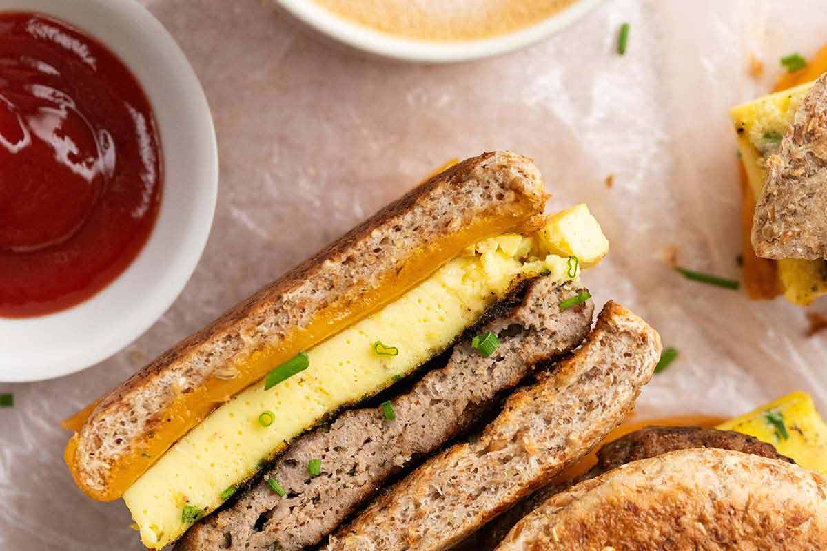 breakfast sausage egg and cheese sandwich with ketchup on side for dipping