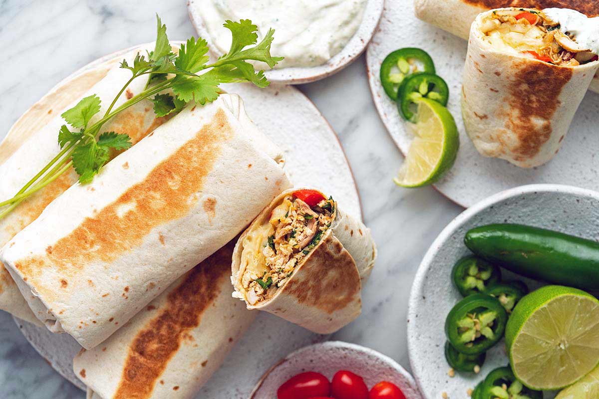 chicken burrito spread with fresh veggies on marble counter