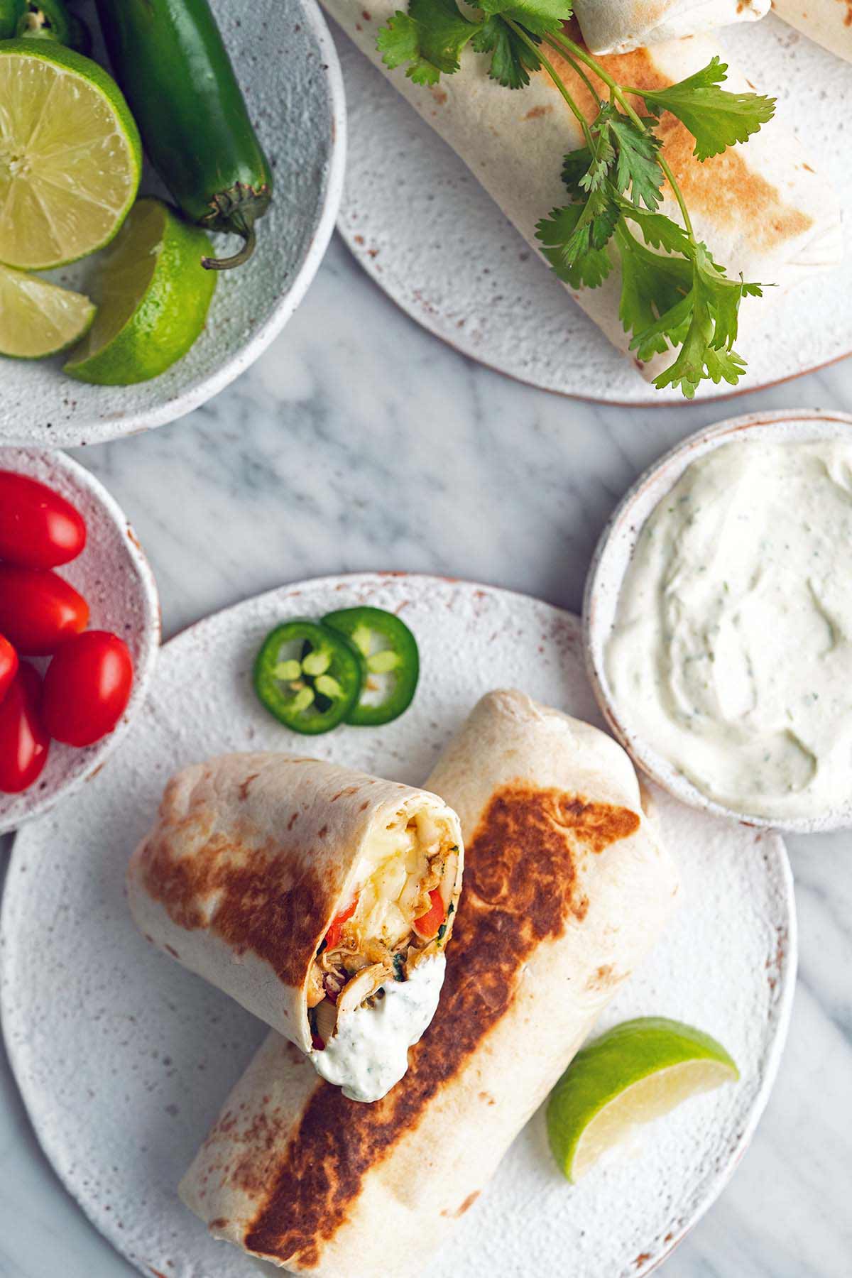 top view of burrito meal with high protein cilantro lime crema recipe on marble countertop