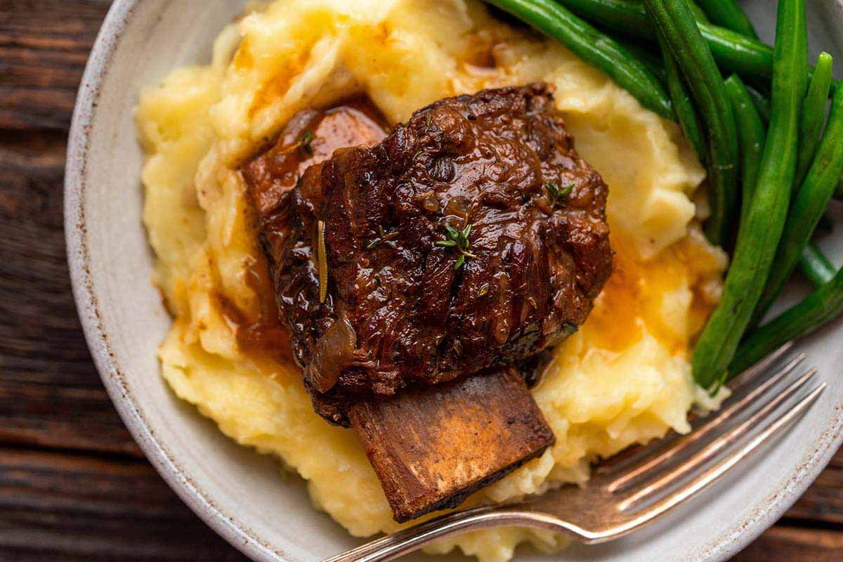 close up top view of slow cooker beef short ribs braised in red wine