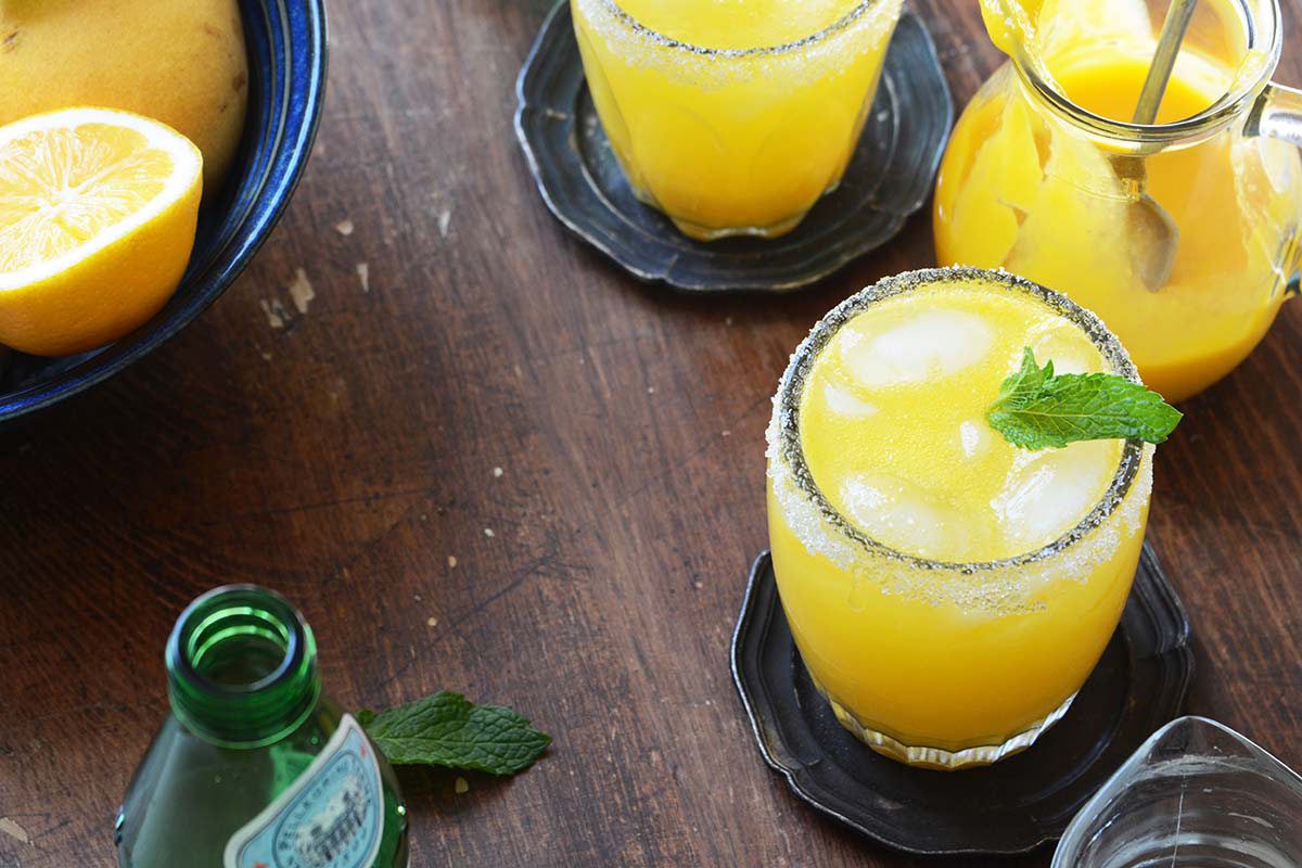 non alcoholic mango drink with Meyer lemon and mint on wooden table