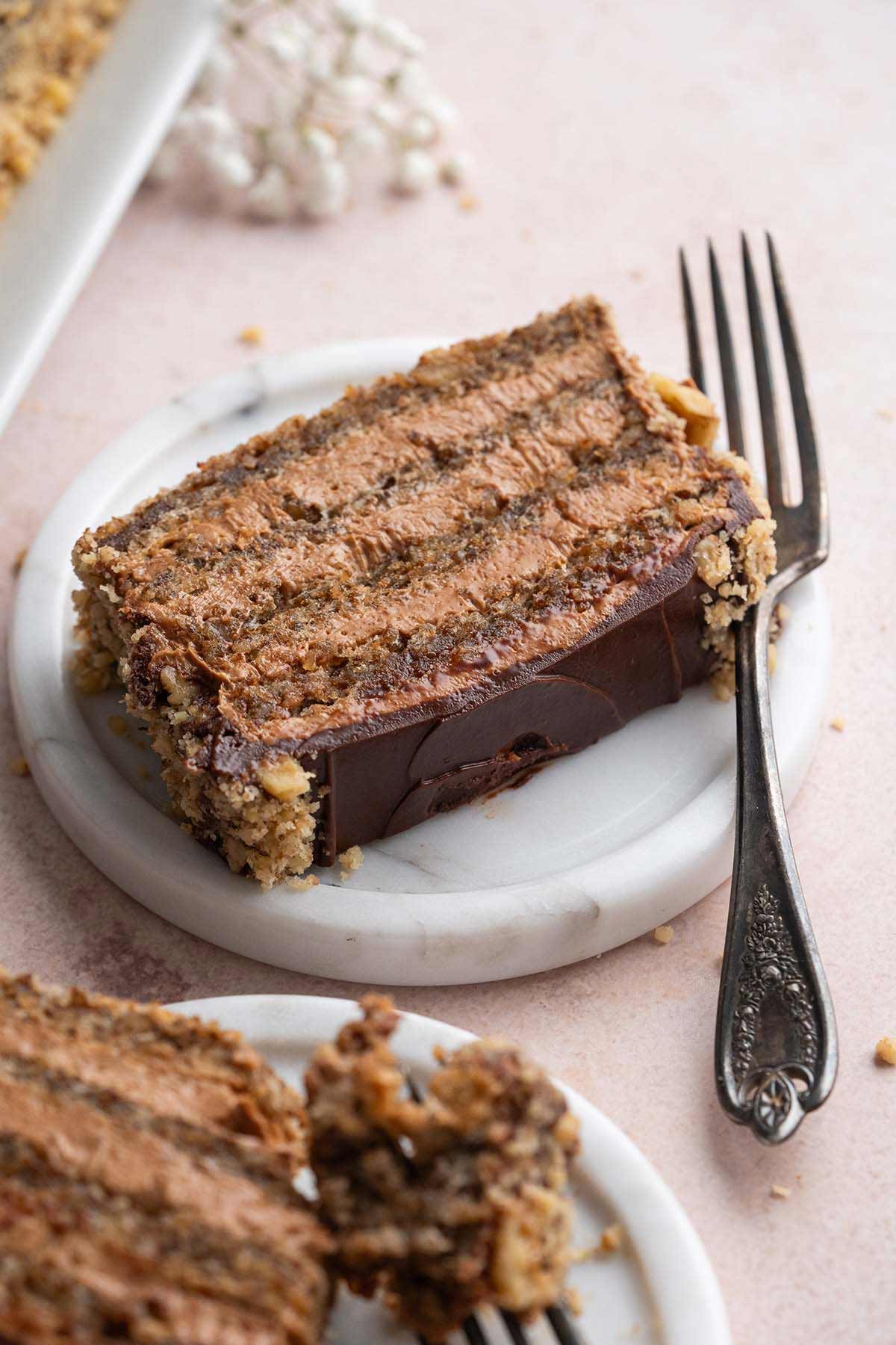 slice of chocolate walnut layer cake on marble plate