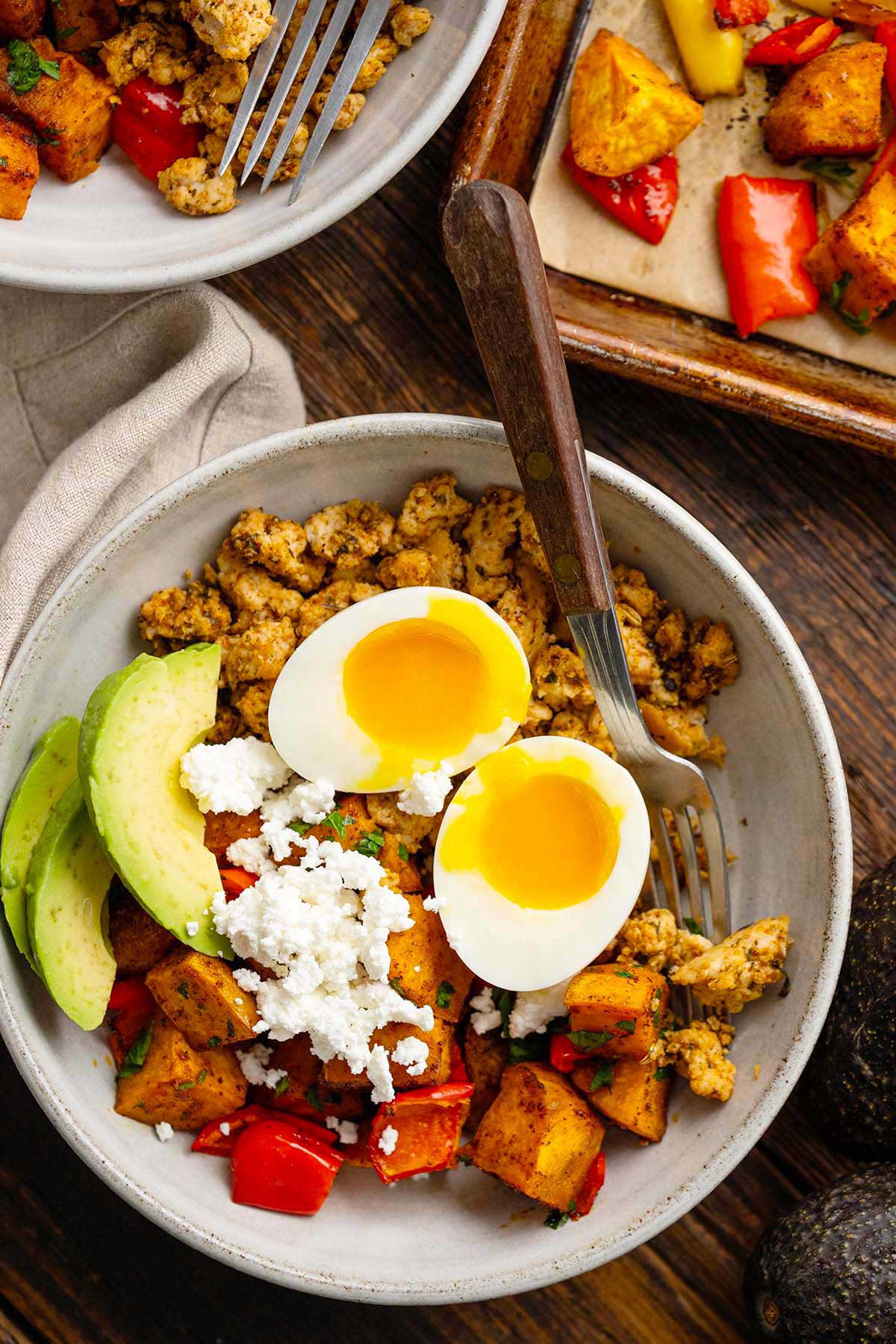 close up top view of sweet potato breakfast bowl with egg and avocado
