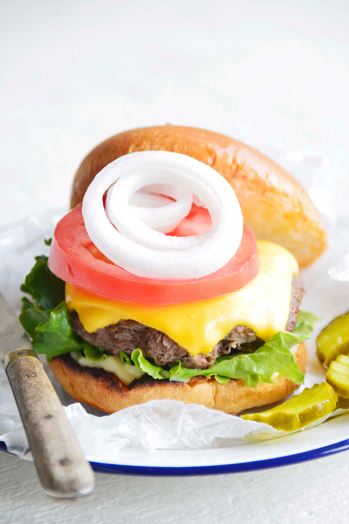 front view of cast iron burger with cheese served on bun