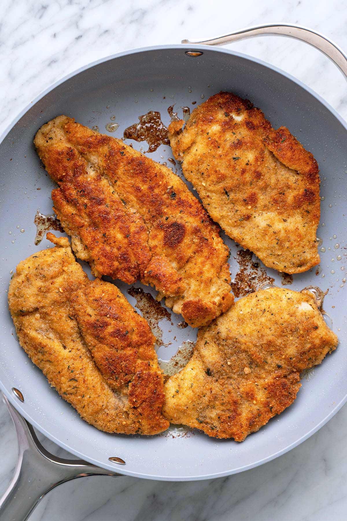 Italian crispy chicken cutlets in skillet