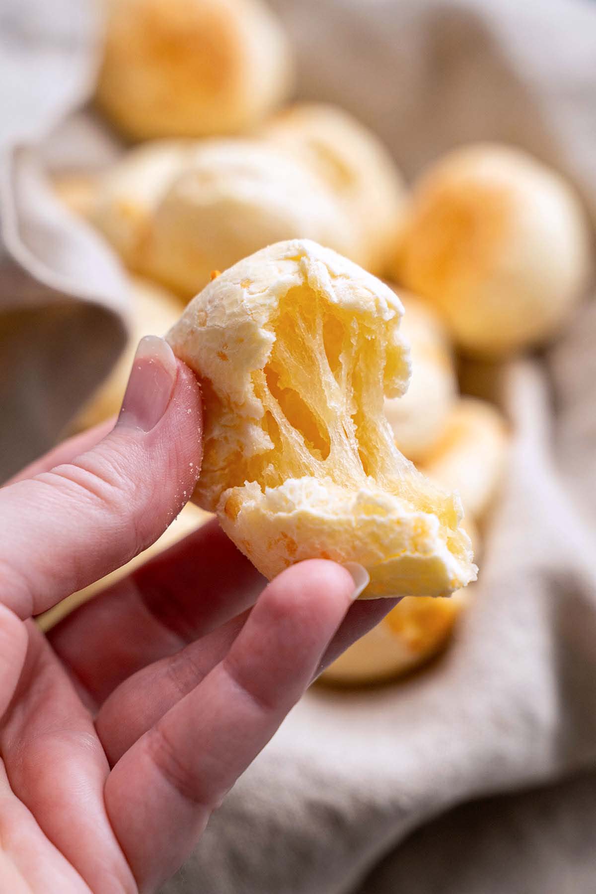 hand holding chewy stretchy brazilian cheese bread