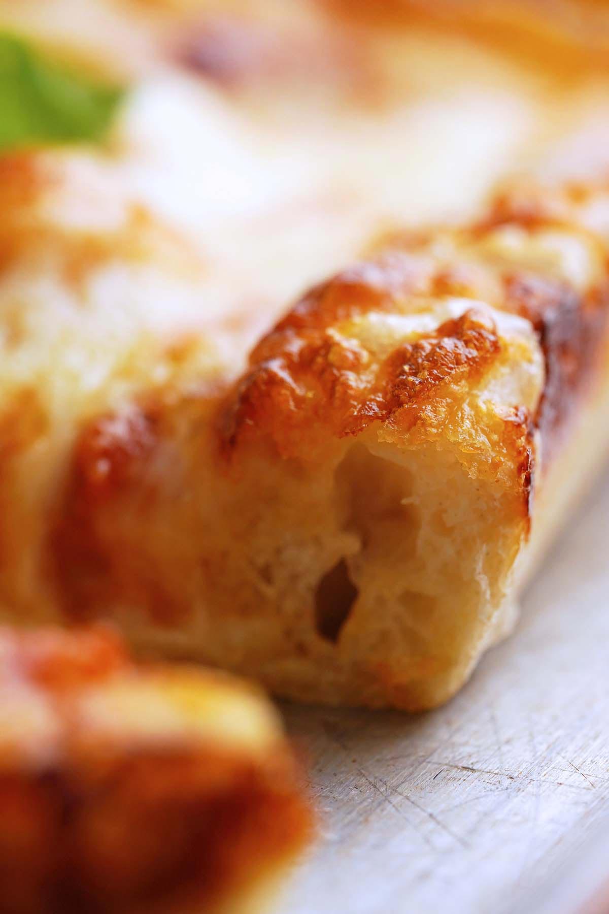 close up of Detroit pizza showing crispy crust with chewy airy texture